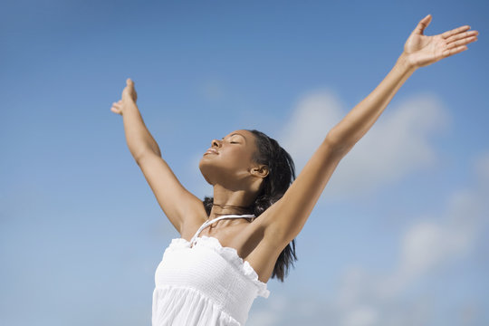 Hispanic woman with arms raised