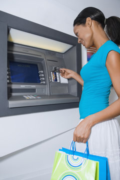 Hispanic woman using atm