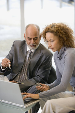 African businesspeople looking at laptop