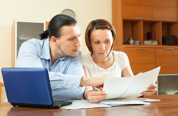 serious young couple reading financial documen