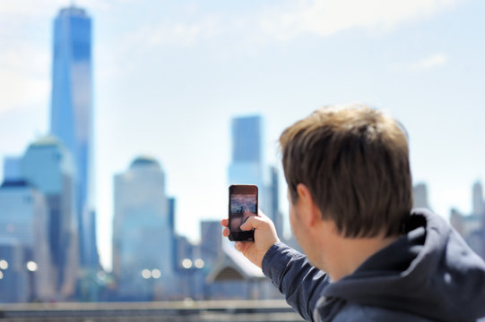 Tourist taking mobile photo of skyscrapers