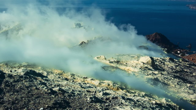 Volcano&rsquo;s island fumarole releasing white steam