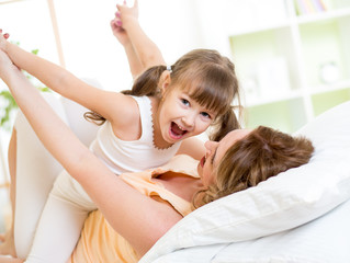 Mother and child having fun in bed