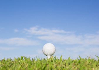 Golf ball on a tee with sky background