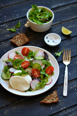 fresh salad with tomatoes and mozzarella on a dark surface