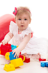 Amazed baby girl playing with toys