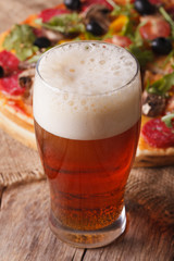 Cold beer closeup on a background of pizza, vertical
