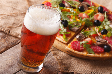 Cold beer and hot pizza on the table close-up horizontal
