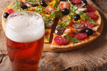 Beer and hot pizza with arugula close-up horizontal
