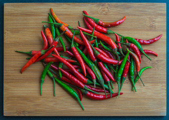 Red and Green chilli pepper on chopping block