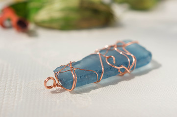 Handmade pendent from glass and a copper wire close up