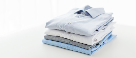 close up of ironed and folded shirts on table - obrazy, fototapety, plakaty