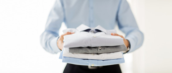 close up of businessman holding folded shirts