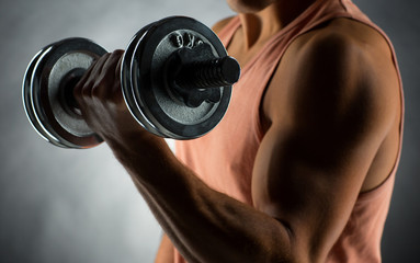 close up of young man with dumbbell