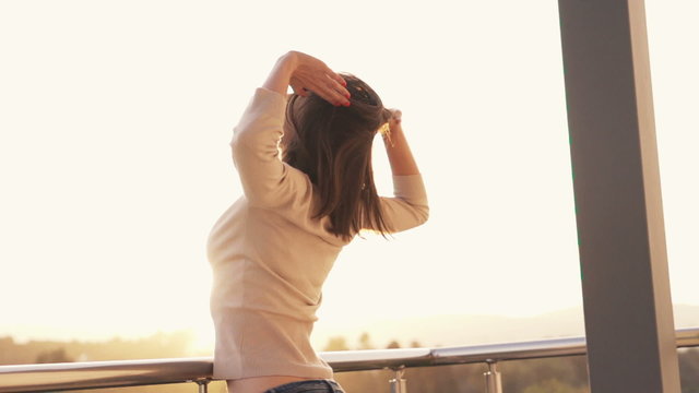 Young woman stretching on balcony in the morning
