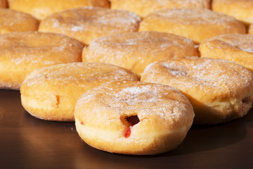 Group of fresh baked cinnamon donuts with raspberry jam. 