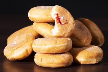 Group of fresh baked cinnamon donuts with raspberry jam. 