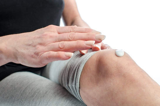 Woman Putting Cream On Her Knee