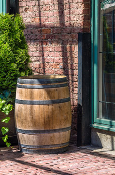 Traditional Wooden Barrel Standing in front of a Brick Wall