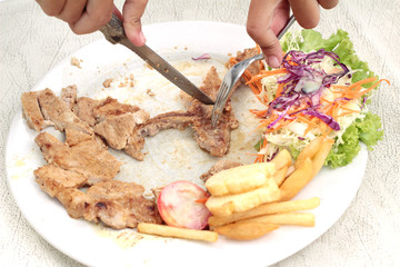 steaks and vegetable salad with french fries.
