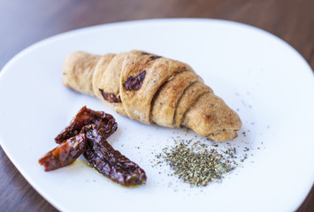 Close-up of baked croissant with spices in a white bowl