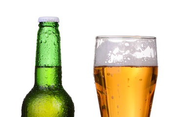 Chilled green bottle with condensate and a glass of beer 