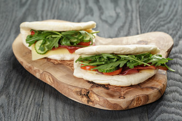 rustic sandwiches with ham arugula and tomatoes in pita bread