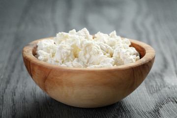 fresh ricotta in olive wood bowl on old table