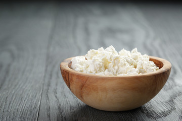 fresh ricotta in olive wood bowl on old table
