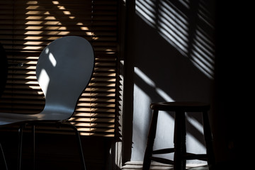 Chair, stool, blinds and shadows