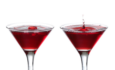 A martini glass on a white background; the water ripples and spl
