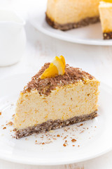 piece of orange cheesecake on a white plate, vertical