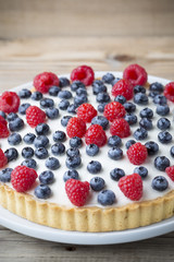 Cake with blueberries and raspberries. Confectionery product.