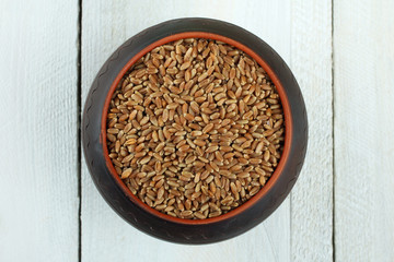 Raw organic spelt on a wooden table