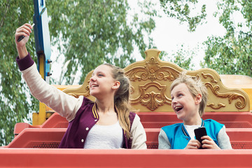 Teens Ride on a Swing and Make  Selfie on the Smartphone