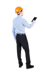Backview of business man in construction helmet stands and enjoy