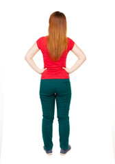 back view of standing young beautiful  woman in jeans.