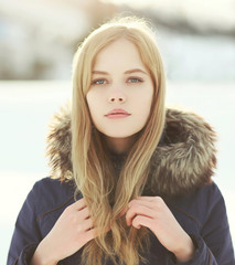 Closeup portrait of pretty blonde girl outdoors in winter day