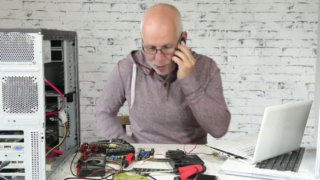 a technician repairing a computer and phone