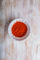 Red pepper in a bowl on wooden table
