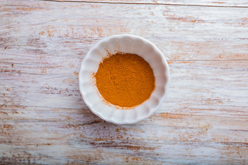 Cinnamon in a bowl on wooden table