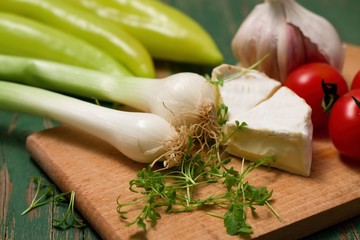 Spring onion and camembert on chopping board
