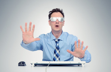 Businessman with glasses of foil in front of computer