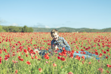 Mother and her little child having fun in a field, flower in for