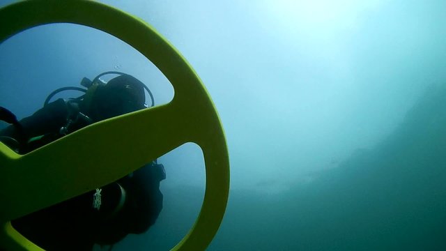 Diver with the metal detector searching  