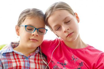 Girls sharing headphones to listen to music