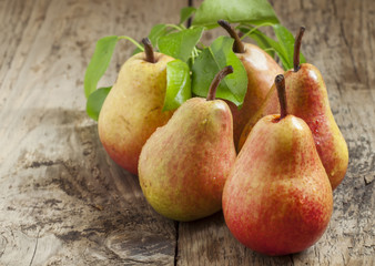 Fresh pink pear with drops of water on wooden table, selective f