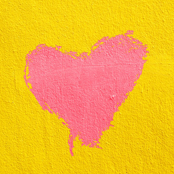 red heart on  yellow cement wall