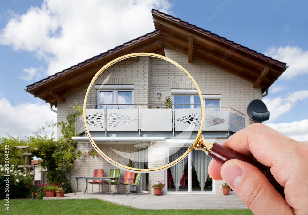 Wall mural Hand With Magnifying Glass Over House