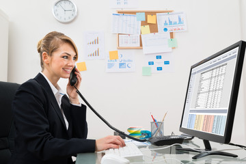 Businesswoman Talking On Telephone At Desk